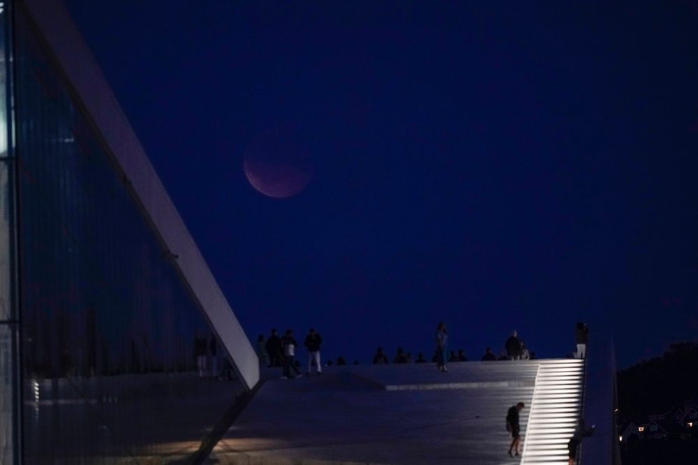 Blodmåne over Operaen i Oslo der flere hadde samlet seg på taket for å se måneformørkelsen.