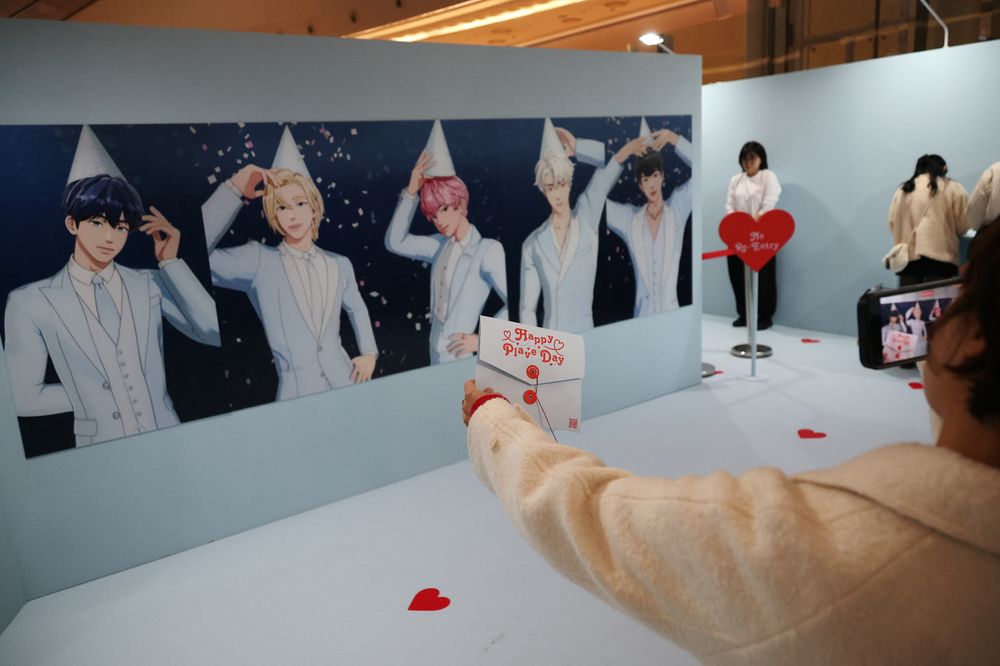 En fan av det virtuelle K-pop-boybandet Plave tar bilder med portretter av medlemmene i en popup-butikk i Seoul, Sør-Korea tidligere i år.