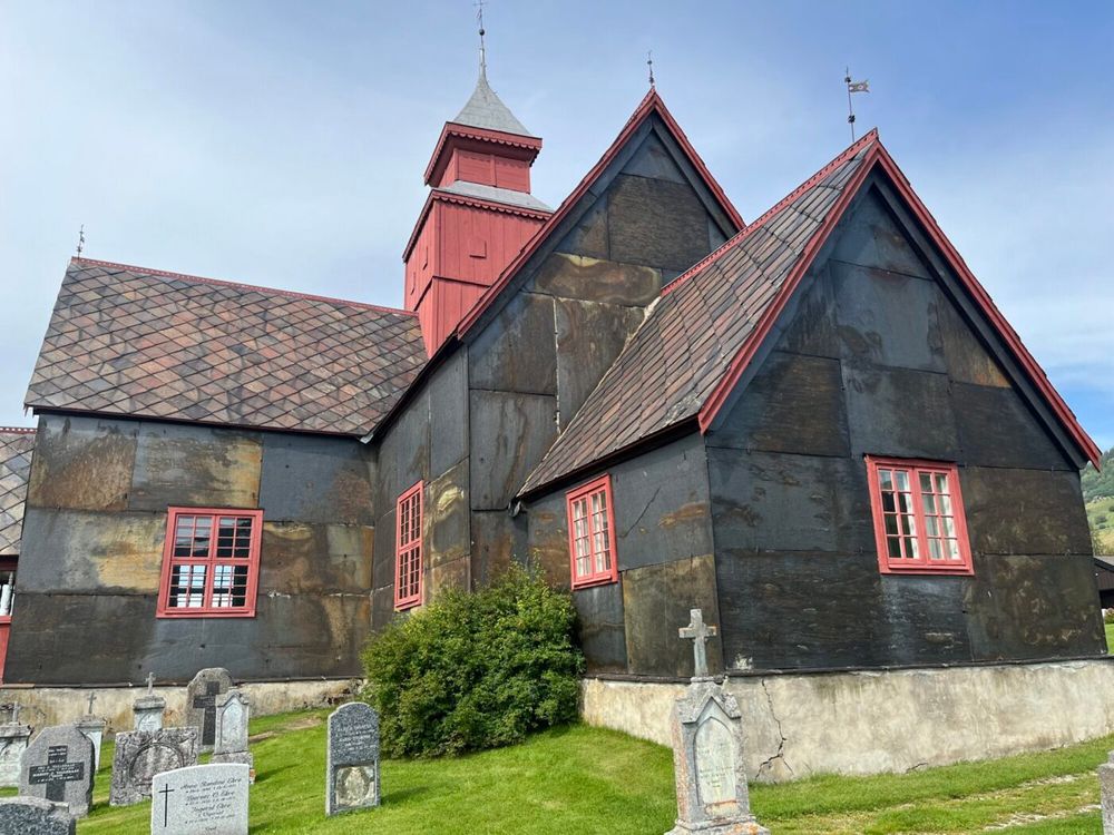 Dovre kirke, oppført i 1736. Kirken fikk nytt tårn og skiferkledning på 1840-tallet, Her ser vi sørlig del med markant rustdannelse og vakkert fargespill.