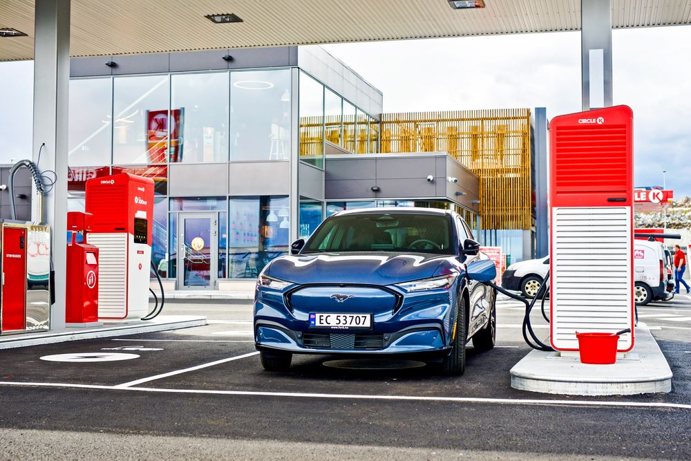 En elbil fra Ford lader på en hurtiglader i Kongsberg. En slik bil vil bli billigere om den leveres før nyttår.
