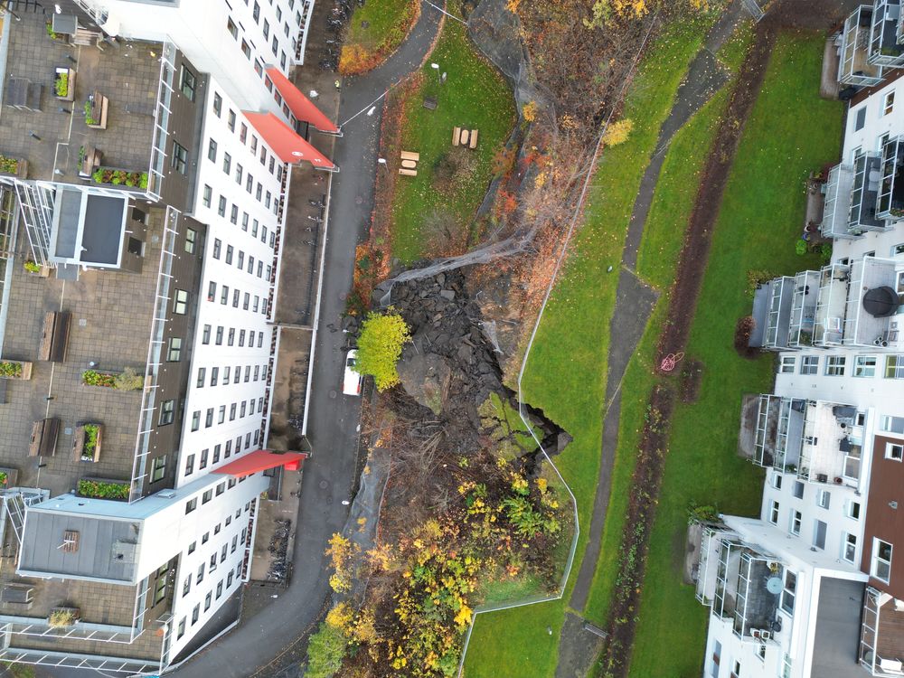 Rester av sikringsnettet som ble revet ned av skredet som gikk søndag er synlig på bildet. Studenthuset til venstre og boligsameiet Sukkertoppen til høyre i bildet.