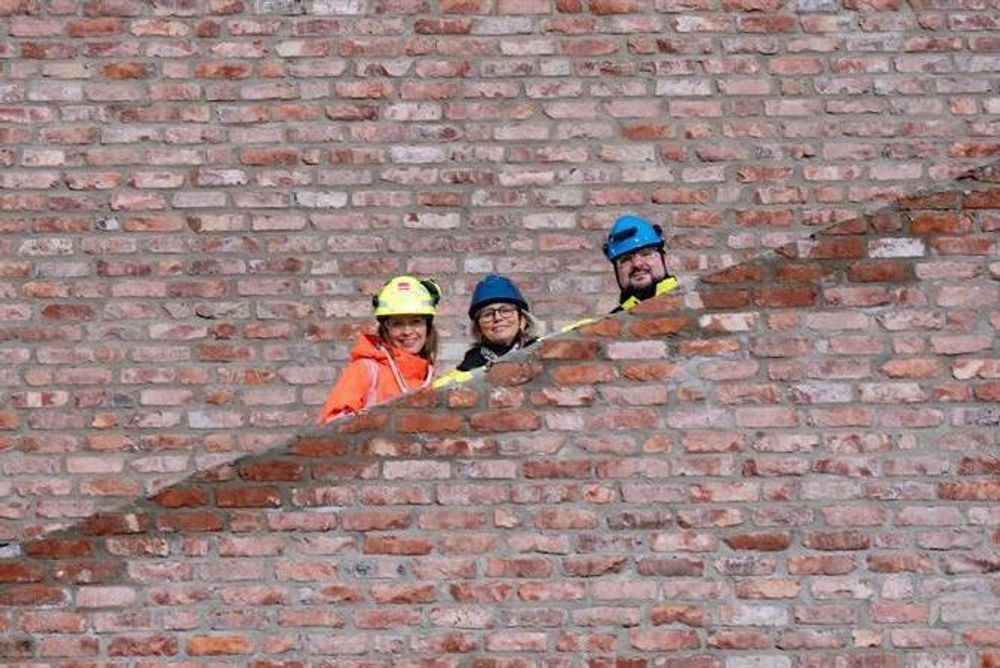 Prosjektleder Hege Hedlevær (i midten) sier de har lagt opp til at skolebygget kan koble seg på fjernvarme etter hvert. Her står hun i en av Cissi Klein videregående skoles trapper, som er bygget med gjenbruksmaterialer.