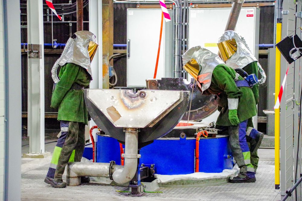 Teknikere inspiserer en av cellene som produserer sjeldne jordartsmetaller hos Elkem.