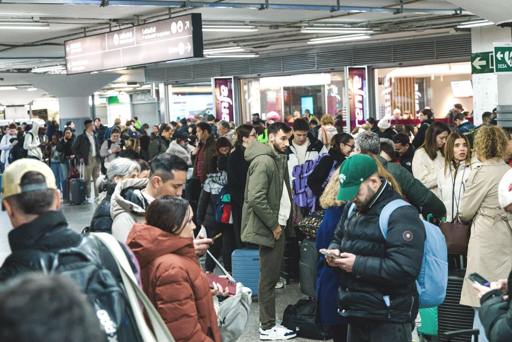 Passasjerer venter på togstasjonen i Madrid søndag kveld, etter at det ble kunngjort at togtrafikken er innstilt som følge av en ulykke der to tog sporet av i Córdoba.