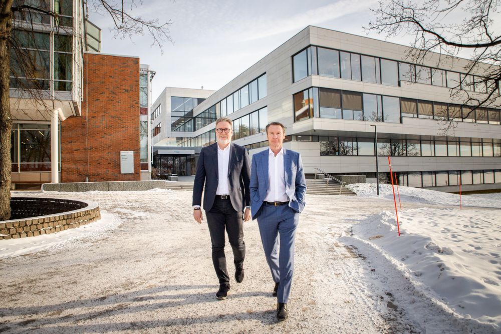Kjetil M. Ebbesberg (t. v.), finansdirektør i DNV, og Knut Ørbeck-Nilssen, fungerende konsernsjef i DNV, foran hovedkontoret på Høvik i Bærum. I 2025 bremset veksten for selskapet, men framover tror de spesielt cybersikkerhet vil sikre veksten. 