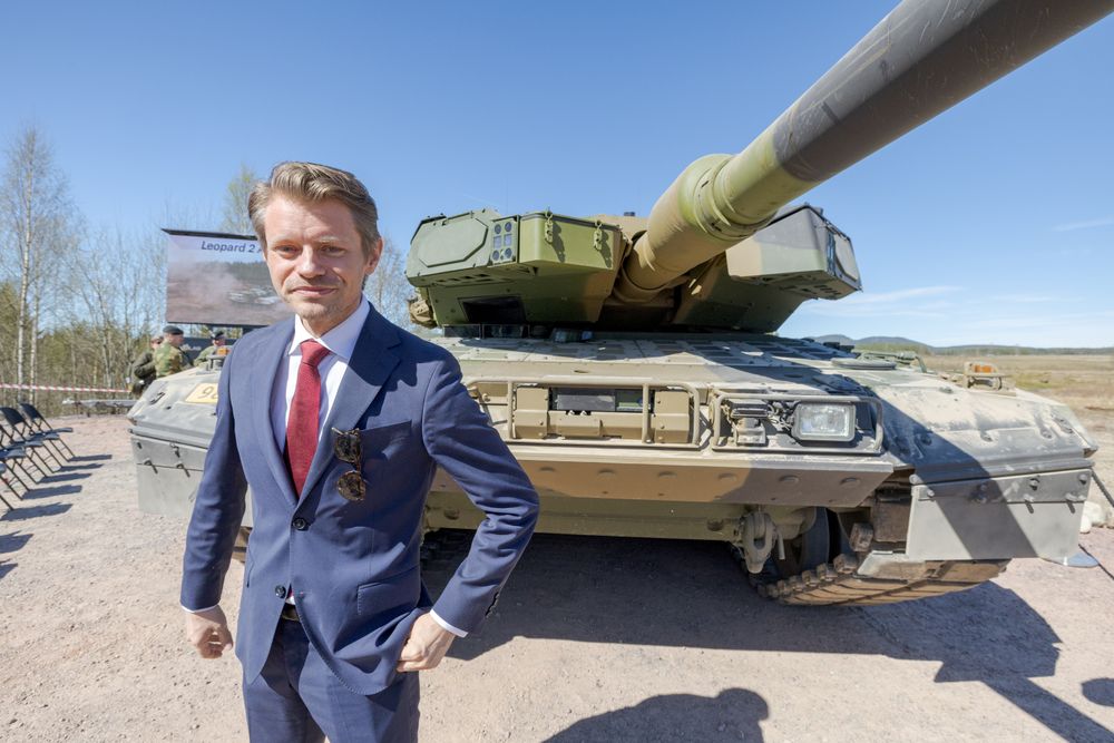 Stortingsrepresentant Peter Frølich (H) foran en Leopard 2A8 NO-stridsvogn på Rena leir.