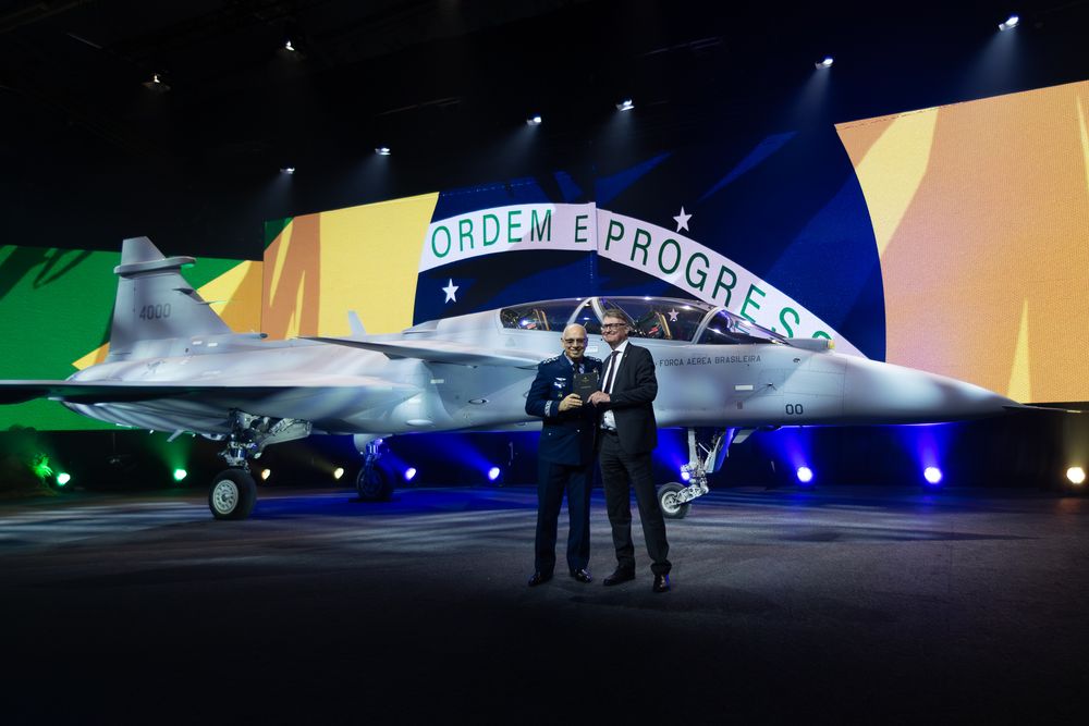 General Marcelo Kanitz Damasceno, sjef for det brasilianske luftforsvaret, og Lars Tossman, sjef for Saabs aeronics-forretningsområde, foran det første Gripen F-flyet som denne uken ble avduket i Linköping. Flyet skal senere leveres til Brasil. Foto fra 2026.