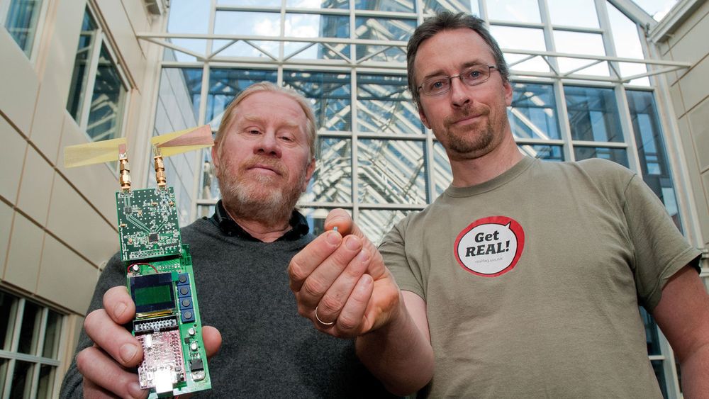 Philipp Häfliger (t.h.) og Tor Sverre Lande ved Institutt for informatikk ved UiO med et apparat som ved hjelp av trådløs energi måler blodsukkeret under huden.