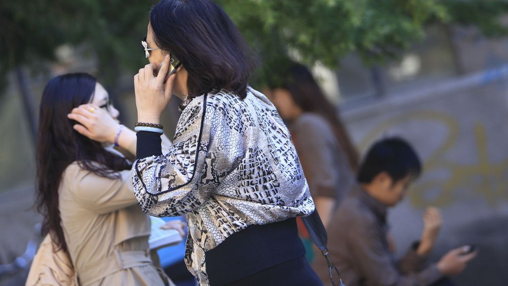 Gatebilde fra Beijing i september i år. Brukere går i stadig større grad over til smartmobiler, helst lokale merker.