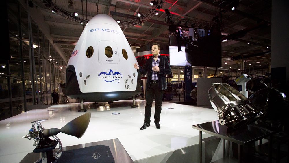 SpaceX-sjef Elon Musk, som også er sjef i Tesla, poserer foran den nye romkapselen som etter planen skal ta med seg mennesker ut i verdensrommet og tilbake igjen allerede i 2017. 