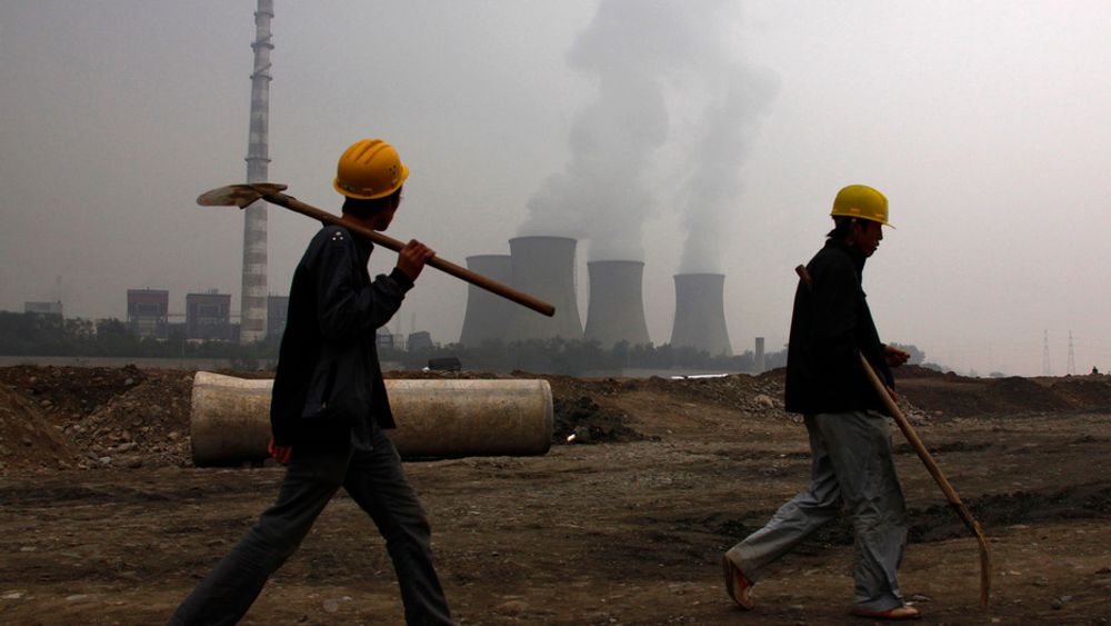 KULL: To arbeidere foran et kullkraftverk utenfor den kinesiske hovedstaden Beijing. Kullkraft er en av de viktigste kildene til utslipp av klimagassen CO2.