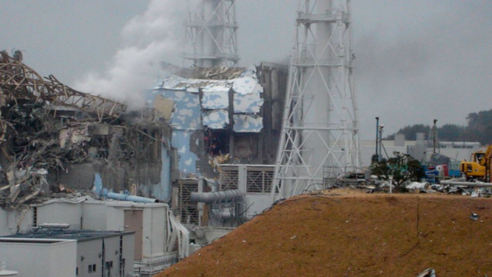 I GRUS: Reaktor 4 (i midten) og reaktor 3 (til venstre) ved Fukushima Daiichi kjernekraftverk i Japan. Bilde tatt 15. mars 2011.
