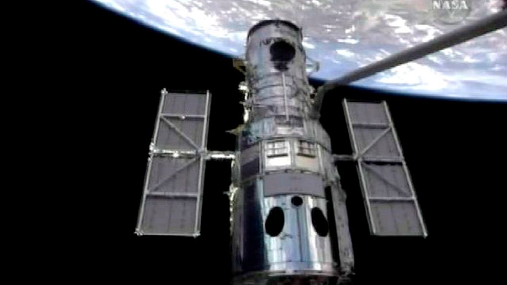 Robotarmen på romferja Atlantis grep onsdag om romteleskopet Hubble og trakk det med inn i romferjas lasterom for en omfattende overhaling.