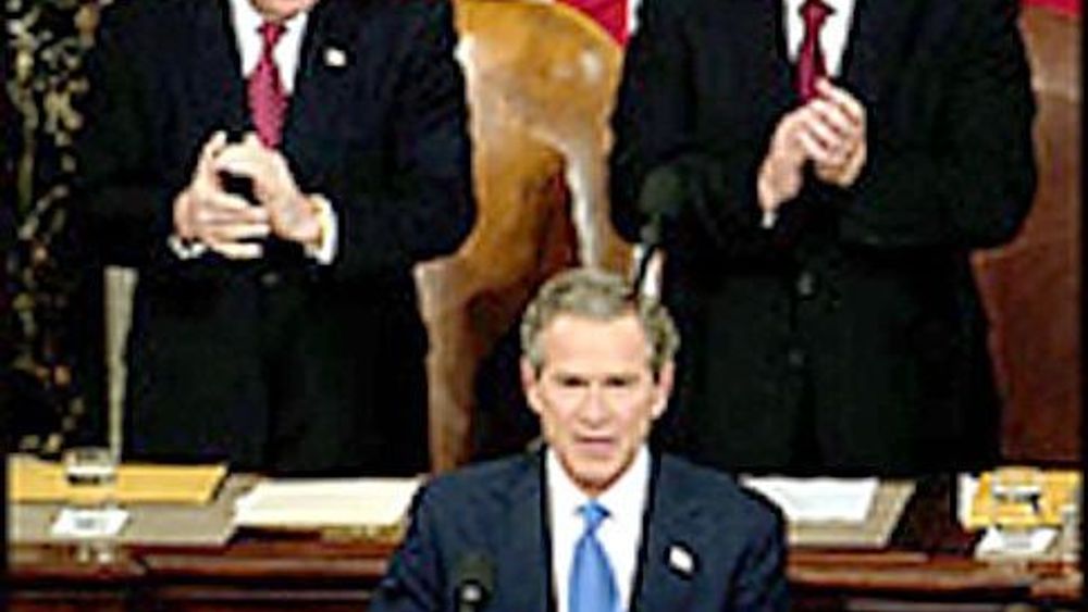 President George W. Bush på talerstolen med visepresident Dick Cheney ivrig applaudrende til venstre bak ham.
