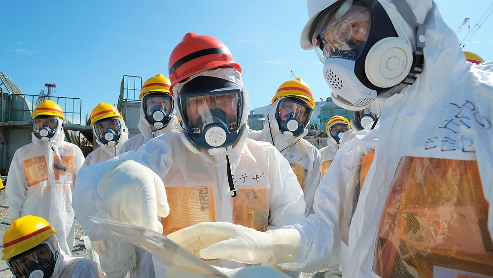 Japans minister for økonomi, handel og industri, Toshimitsu Motegi (i midten), besøker det ulykkesrammede atomkraftverket Fukushima Daiichi ikledd beskyttelsesklær og maske. Målinger har den siste tida avslørt store lekkasjer av radioaktivitet ved kraftverket. 