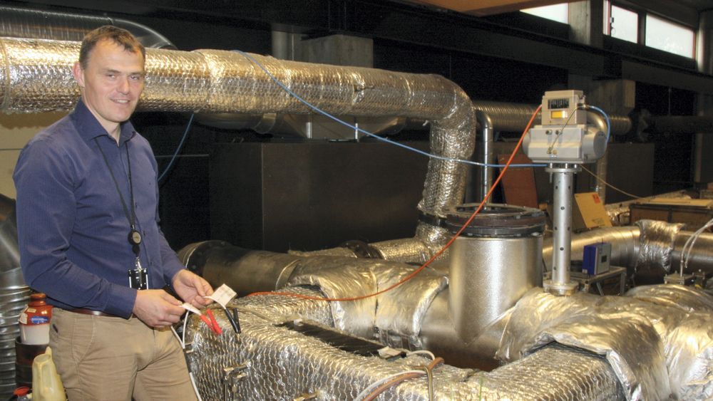Forskningsleder for maritime energisystemer ved Sintef Ocean, Anders Valland, med kabler som kobles på for å måle virkningsgrad for de termoelektriske generatorene. Rørene som stikker ut på siden av eksosrøret er til testing av det aktive systemet.
