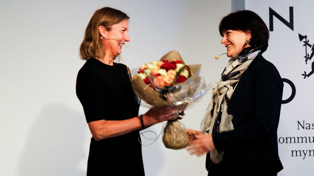 Her mottar den nye Nkom-sjefen, Elisabeth Aarsæther, blomster fra personalsjef Marit Midtstøl Samuelsen under et allmøte mandag 16. oktober.