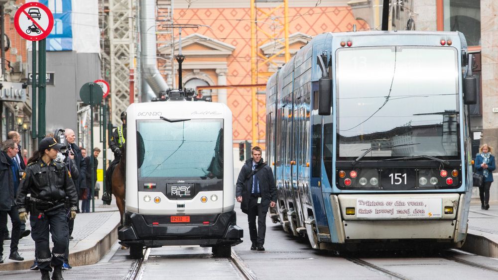 En selvkjørende buss på tur i Oslos gater i april i fjor, trygt flankert av politifolk og sikkerhetsvakter.