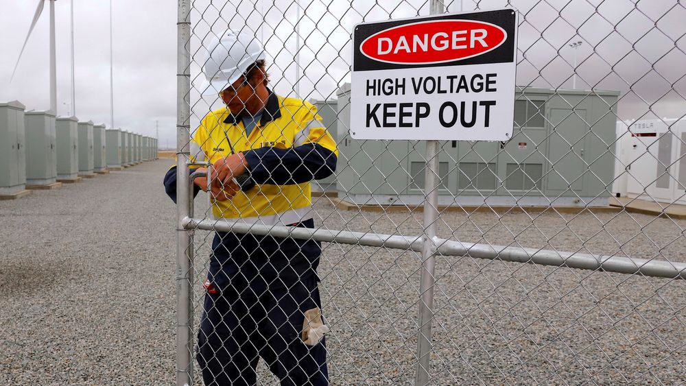 En arbeider sjekker hovedinngangen til verdens største litiumion-batteri under den formelle åpningen av anlegget nær Jamestown, Australia, 1. Desember i fjor. Ekstreme prissvingninger ga nylig penger i kassa hos den private aktøren Neoen.