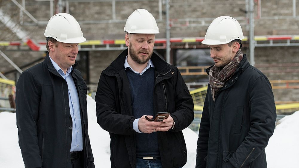 Jon Christian Hillestad (Telia), Frank Wehus (Effera) og Andreas Karlsson (Telia Next) studerer løsningen som skal gi løpende kontroll over personell og utstyr på byggeplasser.
