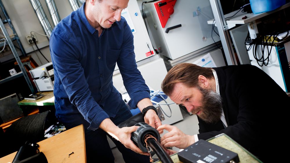 Sigbjørn Kolberg, forsker ved Avdelingen for smarte sensorsystemer ved Sintef Digital og Morten Huseby, daglig leder i Wirescan, monterer det nyutviklede målesystemet på kabelen i kjelleren hos Sintef.