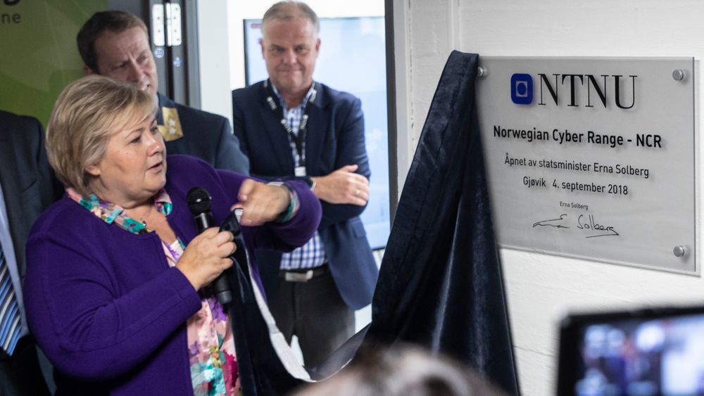 Erna Solberg sto for den offisielle åpningen av Norwegian cyber range. Etter å ha avduket skiltet tok hun seg tid til å brette duken pent sammen før hun overleverte den til instituttlederen.
