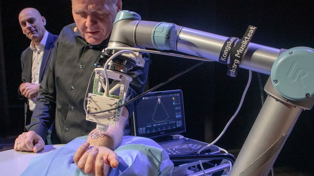 Her undersøkes Sigve Brekke av en robot som styres av helsepersonell via 5G-nettet. Ekstremt lav forsinkelse er essensielt for denne typen bruksområder. I bakgrunnen skimtes konstituert leder i Telenor Norge, Bjørn Ivar Moen. 