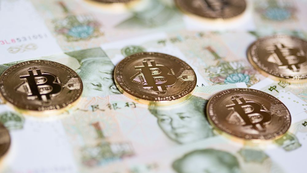 Bitcoins over the background made of Chinese yuan
