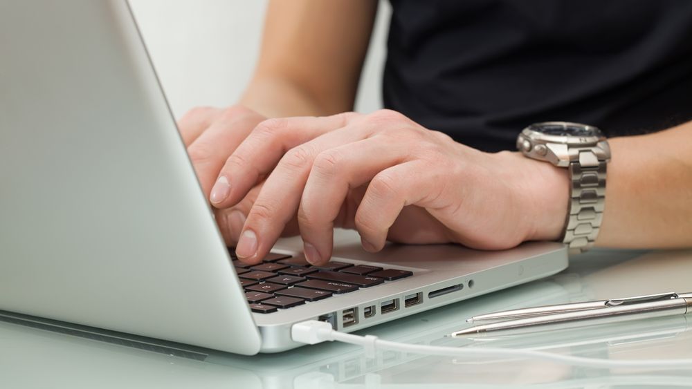 Businessman typing on a notebook (shallow DOF, hand in focus)