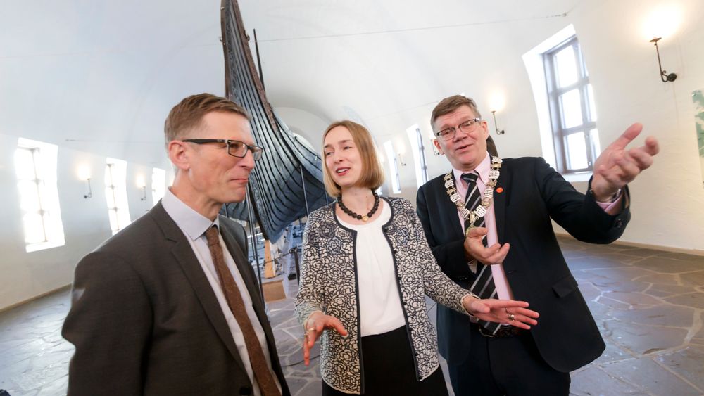 Museumsdirektør Håkon Piene Glørstad (fra venstre), kunnskapsminister Iselin Nybø (V) og UiO-rektor Svein Stølen foran Osebergskipet i Vikingskipmuseet. Som en del av Granavold-erklæringen har de fire borgerlige partiene blitt enige om at det skal bygges et nytt museum for vikingskipene og vikingtidssamlingene.