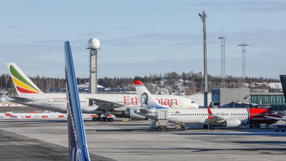 Et Boeing 737 Max-8-fly fra Norwegian (SE-RTC) står ved gaten på Oslo lufthavn. Bak står et Boeing 777-260 LR (ET-ANP) fra Ethiopian Airlines.