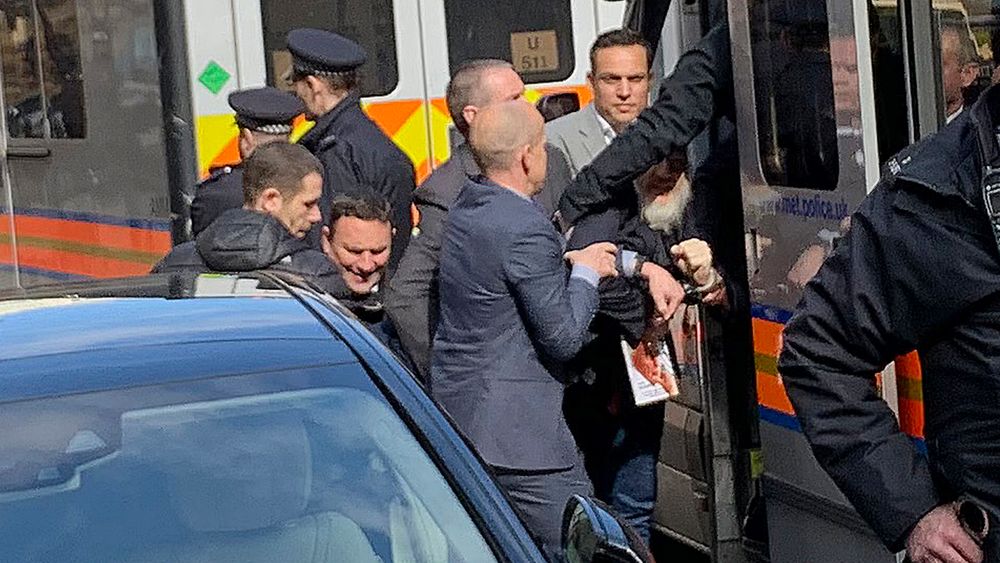 Britisk politi tvinger WikiLeaks-gründeren Julian Assange inn i en politibil utenfor Ecuadors ambassade i London. 