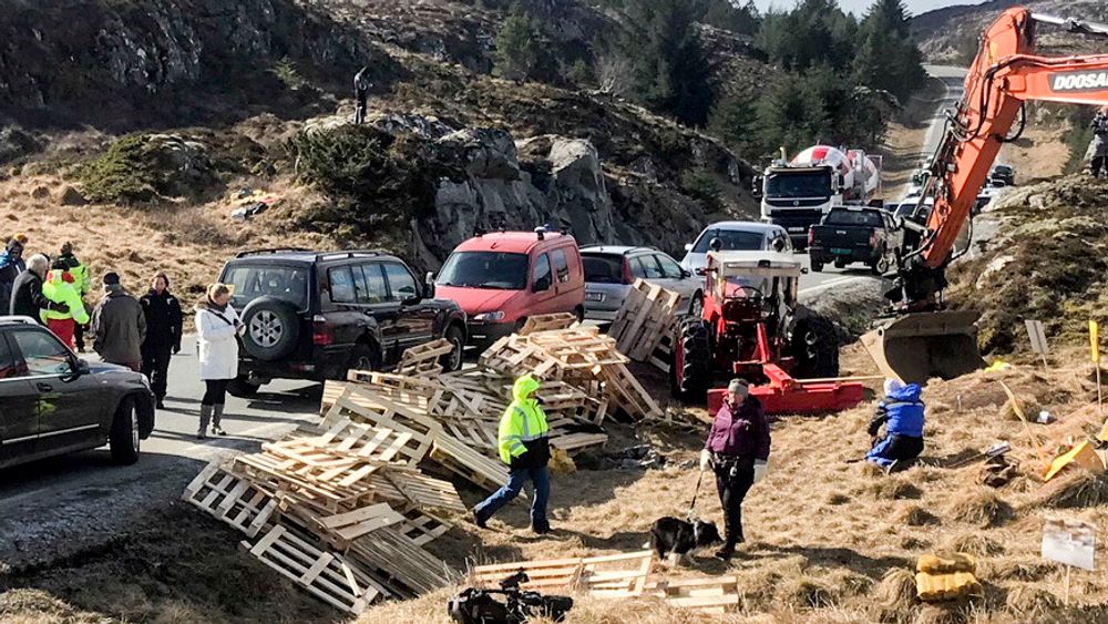 Politiet har bøtelagt demonstrantenes biler som står langs veien på Frøya. Pallene som ble levert av Salmar-eier Gustav Witzøe ble brukt til å hindre anleggstrafikk til å kjøre forbi.
