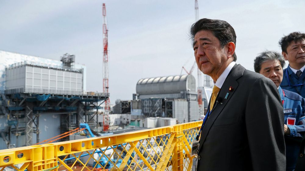 Japans statsminister Shinzo Abe besøkte atomkraftverket i Okuma søndag. Her står Abe utenfor reaktor nummer 2 (til venstre) og nummer 3 (til høyre).