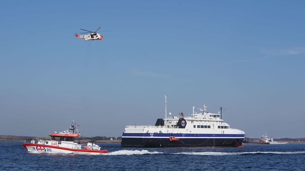 Luftforsvarets Sea King redningshelikopter og en av Redningsselskapets båter ved passasjerfergen MF Værøy. Øvelse Nord er Norges største kriseøvelse.