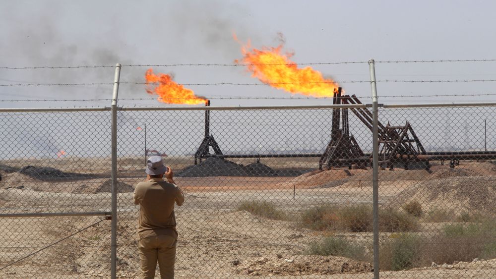 Illustrasjonsbilde: En journalist tar bilde av Exxons oljefelt West Qurna-1 nærme Basra 17. juni 2019.