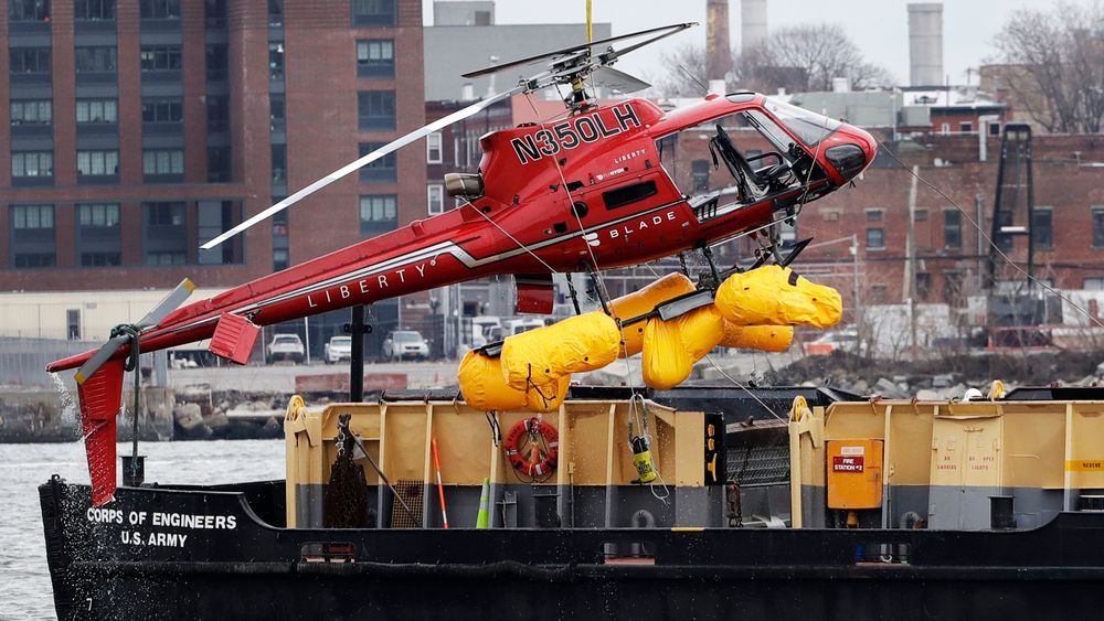 FILE - In this March 12, 2018 file photo, a helicopter, which crashed the previous day, is hoisted by crane from the East River onto a barge, in New York. The helicopter company, FlyNYON, exploited a regulatory loophole to avoid stricter safety requirements, federal investigators said Tuesday, Dec. 10, 2019. (AP Photo/Mark Lennihan, File)
