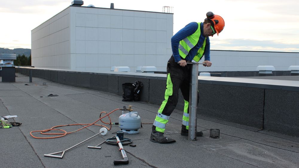 Tor Ove Nesset installerer en av sensoren på taket til Tine meierier i sommer.