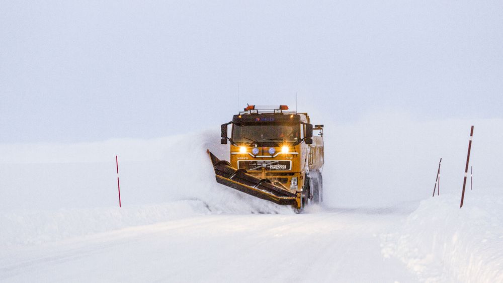 Snøbrøyting i blåtimen. Brøytebil på riksvei 890 Kongsfjordfjellet. Tana kommune. Finnmark.Snow Plough in the blue hour on a mountain road at Finnmark County. Northern Norway.