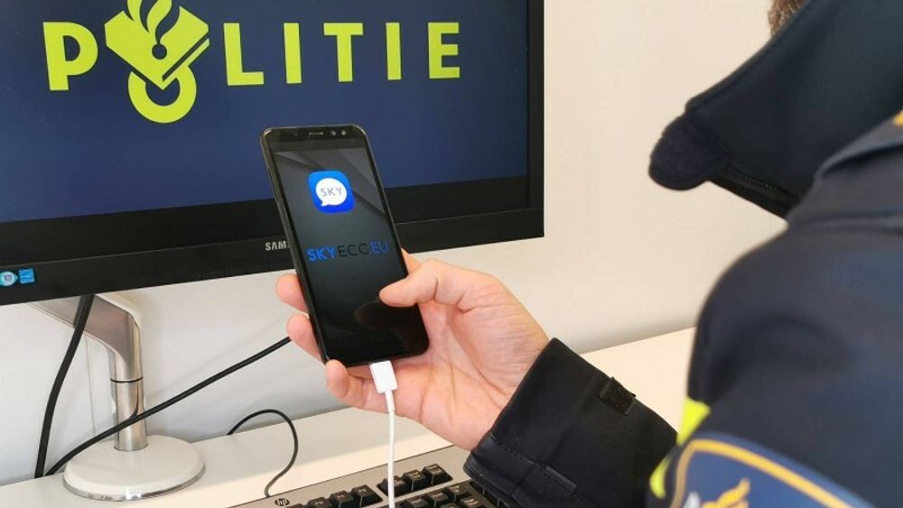 Nederlandsk politimann med en smartmobil som tilsynelatende kjører Sky ECC-appen. Selskapet som står bak tjenesten, hevder derimot at appen på bildet er falsk. Politi fra flere europeiske land har samarbeidet i denne saken.