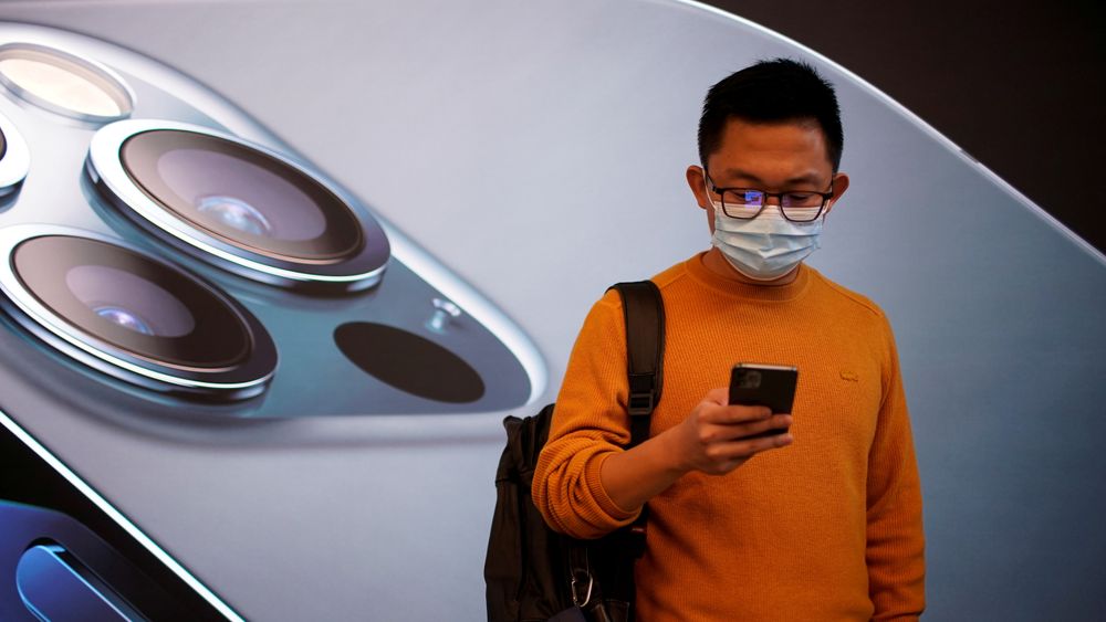En mann bærer ansiktsmaske mens han venter i en Apple Store i Shanghai, Kina ved lansering av Iphone 12 i fjor høst.