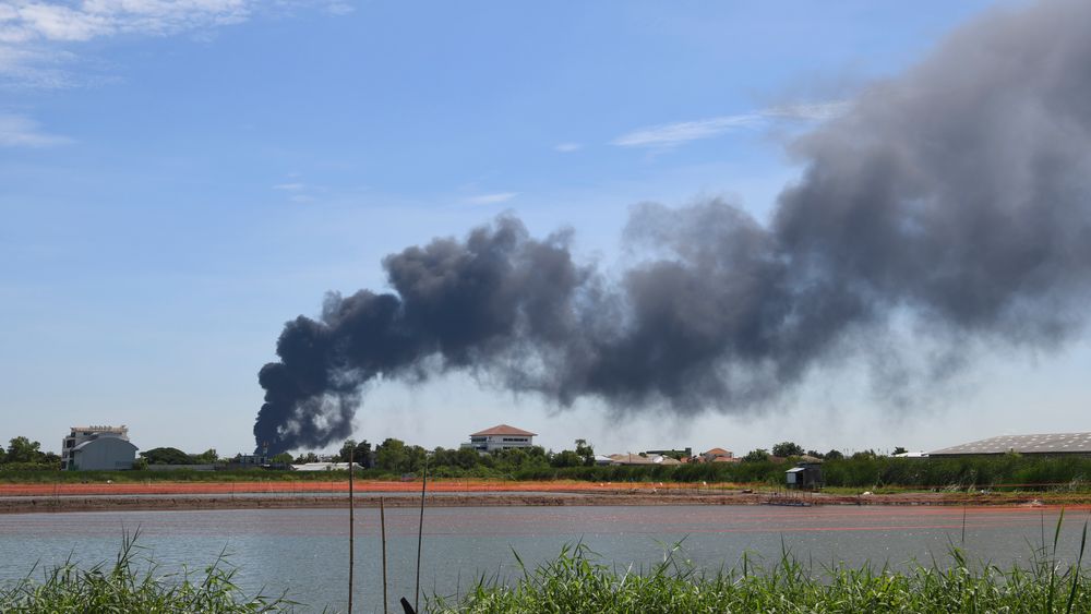 Røyk stiger til værs etter en eksplosjon på en fabrikk like ved hovedflyplassen i Bangkok.