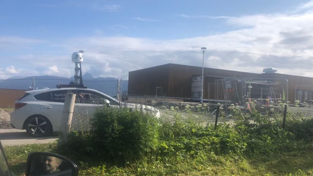 Vinket til fotografen: Apple-bilen passerer her Ibestad sykehjem på øya Rolla sør i Troms og Finnmark.
