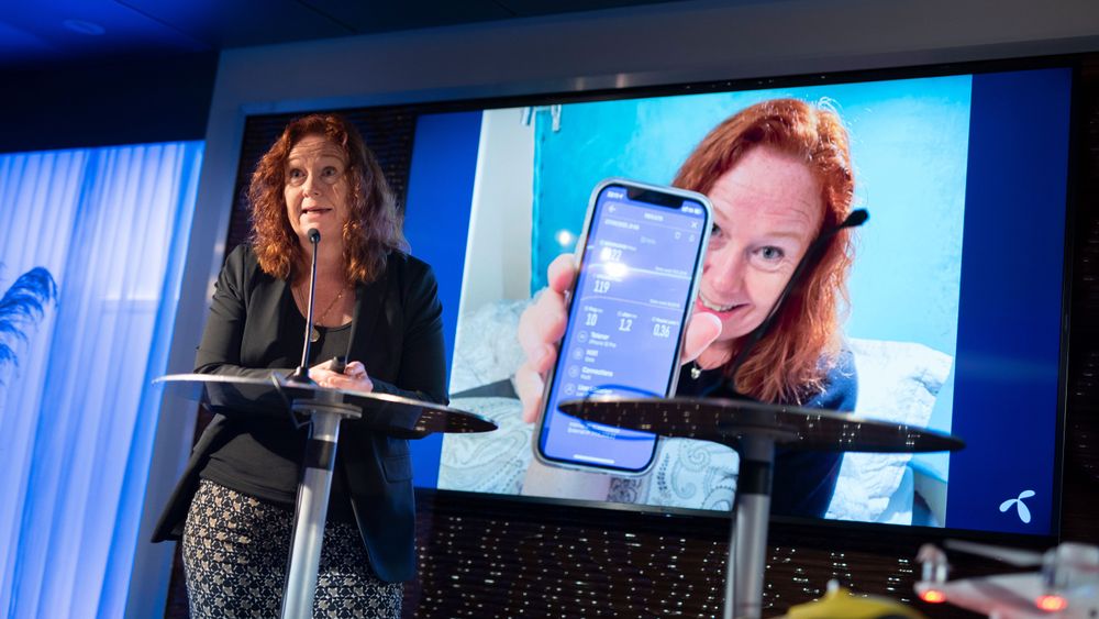 Teknologidirektør Ingeborg Øfsthus i Telenor presenterte Telenors planer for utbygging av 5G. Her foran et bilde av seg selv der hun stolt viser at hun oppnådde 1122 Mbit/s hastighet på mobilen fra soverommet sitt. 