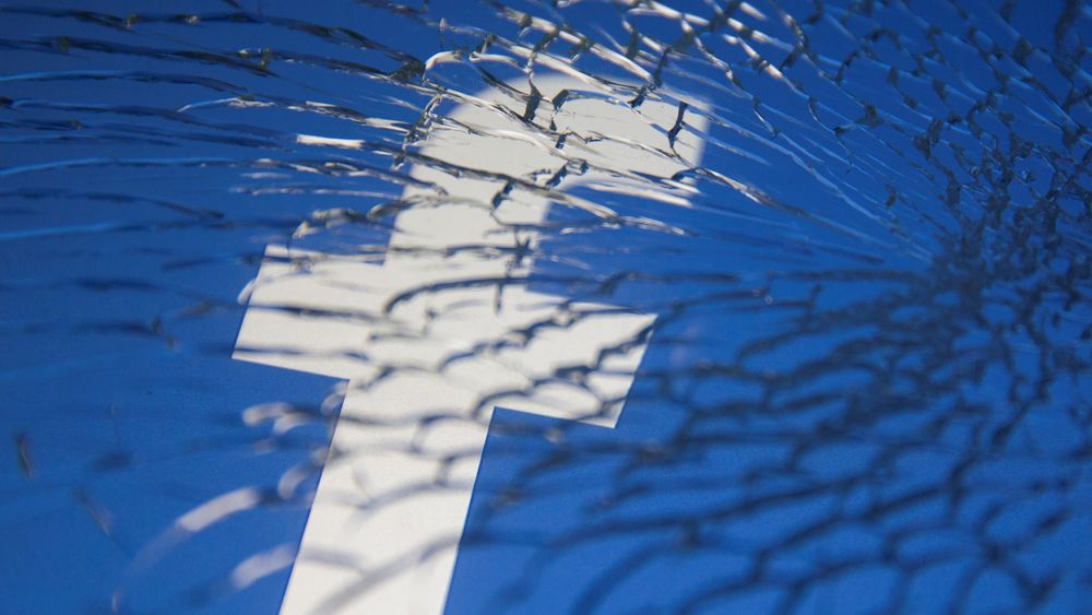 Facebook-logoen sett gjennom knust glass.