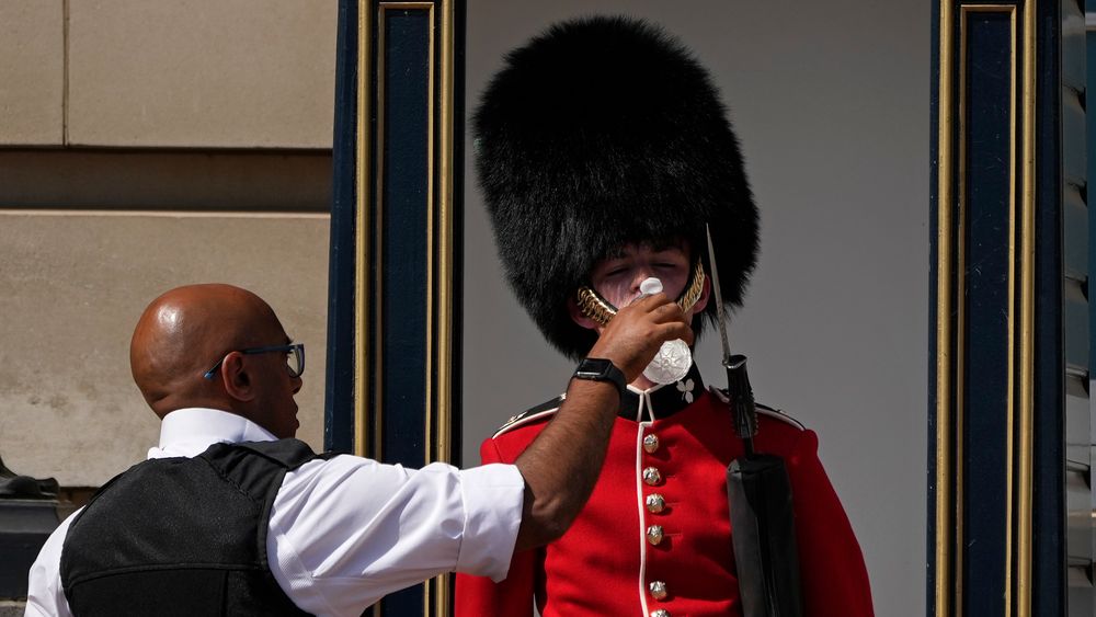 En politibetjent gir vann til en soldat i London mandag.
