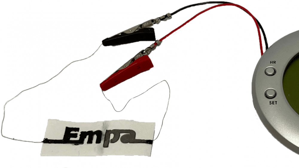 Ved det sveitsiske forskningsinstituttet EMPA har man utviklet et papirbatteri som aktiveres med to dråper vann og gir nok strøm til små elektriske apparater som bare skal brukes én gang. Her er det en vekkerklokke med LCD-display.