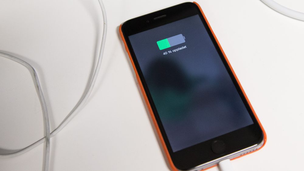 En gammel Iphone under lading. De aller fleste lar mobiltelefoner de ikke lenger bruker, bli liggende hjemme i skuffer og skap.