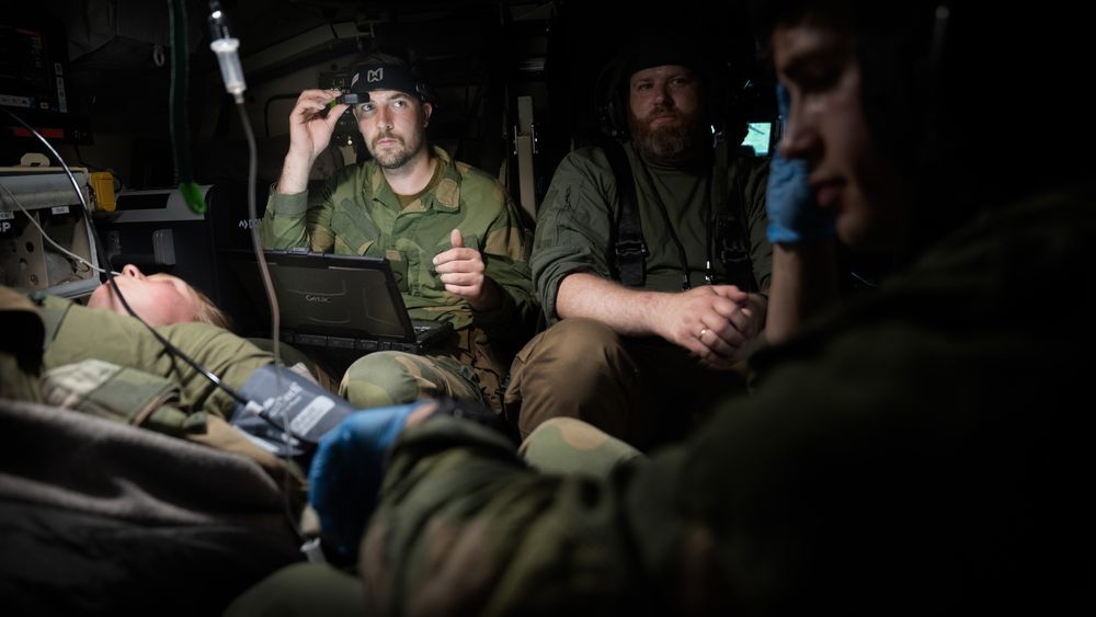 Combat medic Tinius Fjærn prøver å redde en såret soldat med en lege på øyet, mens opplæringsansvarlig i Bliksund, Otto Andre Haaland, assisterer ved siden av. I forgrunnen jobber medic Lars Olav Joa med pasienten.