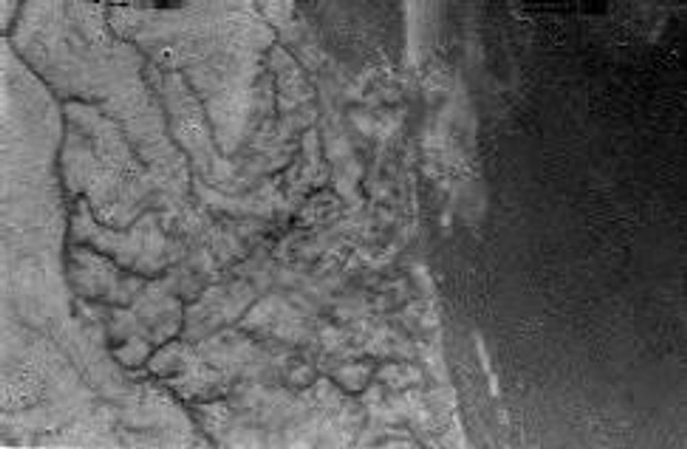 Dette bildet av Titan er tatt i 16,2 kilometers høyde mens Huygens var på vei ned mot Saturns måne. Bildet viser  ifølge ESA klare tegne på kanaler som munner ut mot en kystlinje. Foto: ESA